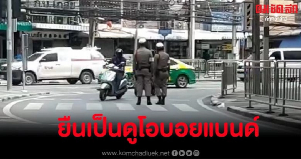 ตำรวจคู่ดูโอยืนถือใบสั่งขวางทางโค้งกลางถนน ตำรวจคู่ดูโอยืนถือใบสั่งขวางทางโค้งกลางถนน