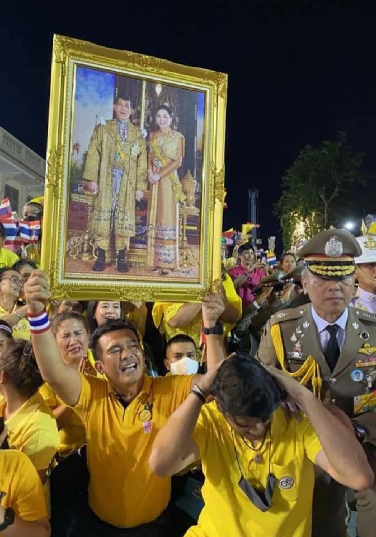 ในหลวงทรงพระอักษรบนพระบรมฉายาลักษณ์ของประชาชนที่เฝ้ารับเสด็จ