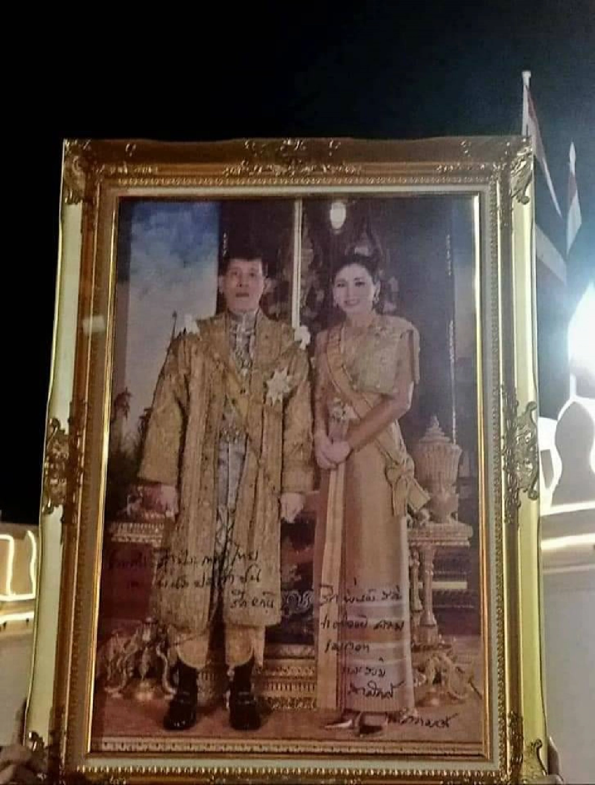 ในหลวงทรงพระอักษรบนพระบรมฉายาลักษณ์ของประชาชนที่เฝ้ารับเสด็จ