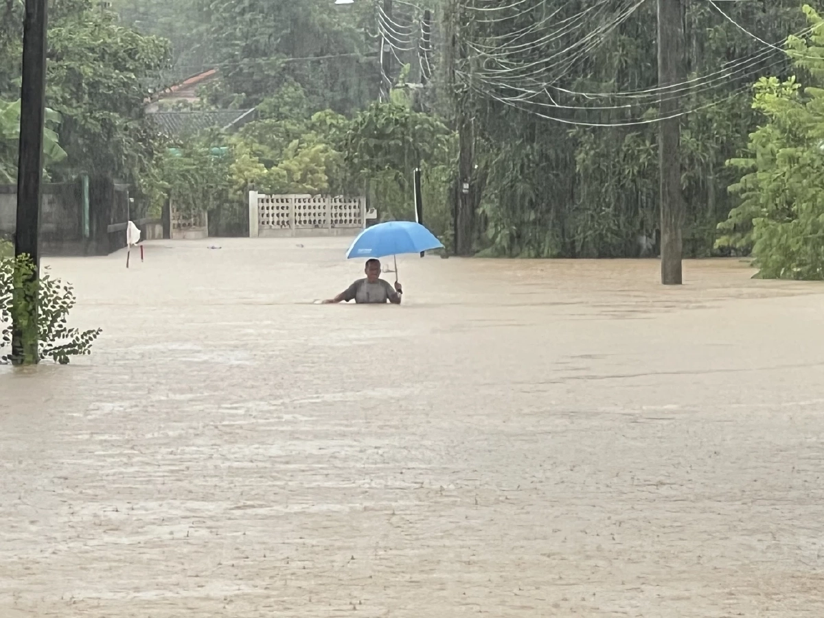 ชาวบ้านเดินลุยน้ำท่วมสูง และฝนตกตลอดเวลา