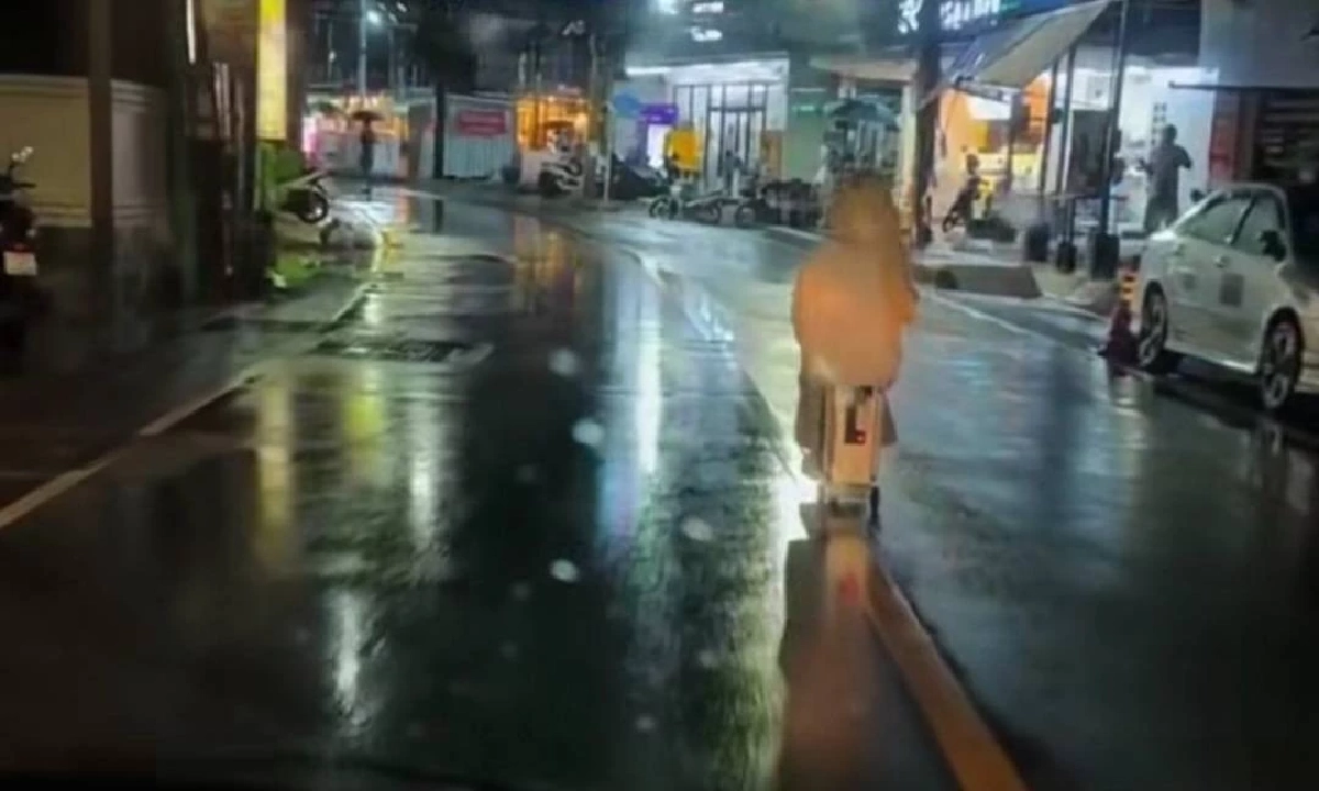 ฝนตกก็ไม่หวั่น! สาวต่างชาติ นั่งกระเป๋าไฟฟ้ากลางถนนป่าตอง หวั่นเกิดอุบัติเหตุ